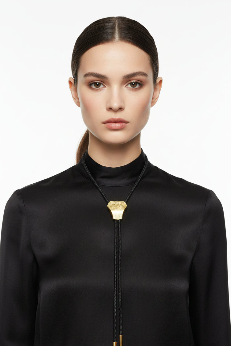 Gold textured bolo tie on a white background