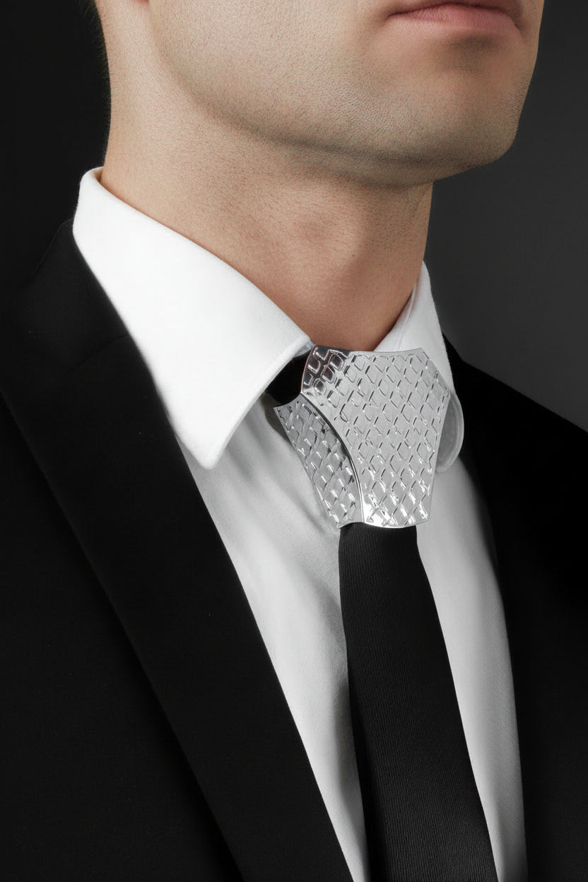 Silver bow tie on a black suit with white shirt against a dark background