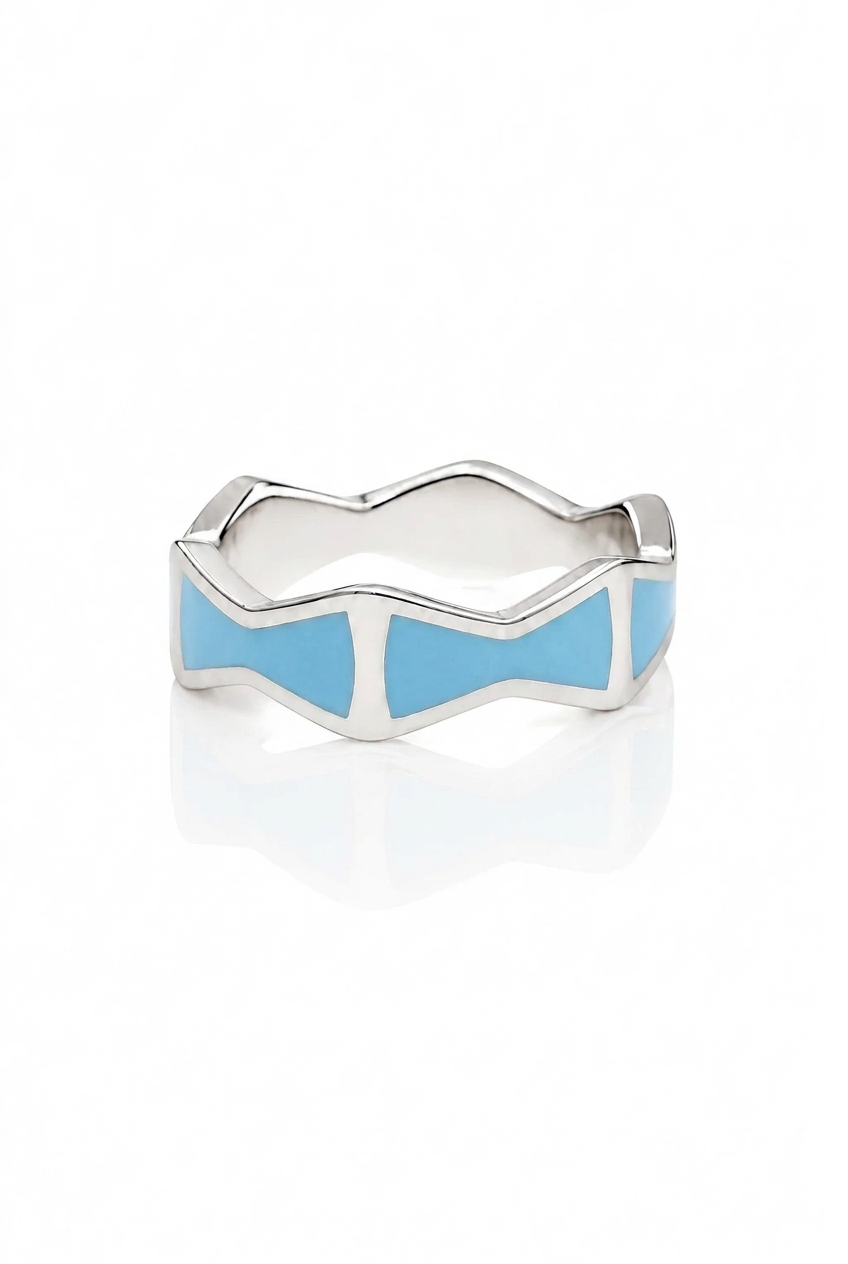 A silver ring with a wavy, geometric design and light blue enamel inlay, shown on a clean white background with a soft reflection.