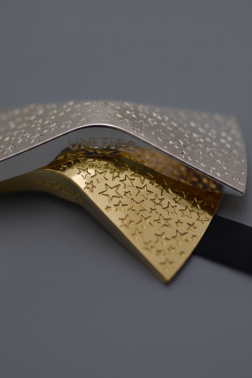 Gold and silver bow ties jewelry with star patterns on a gray background