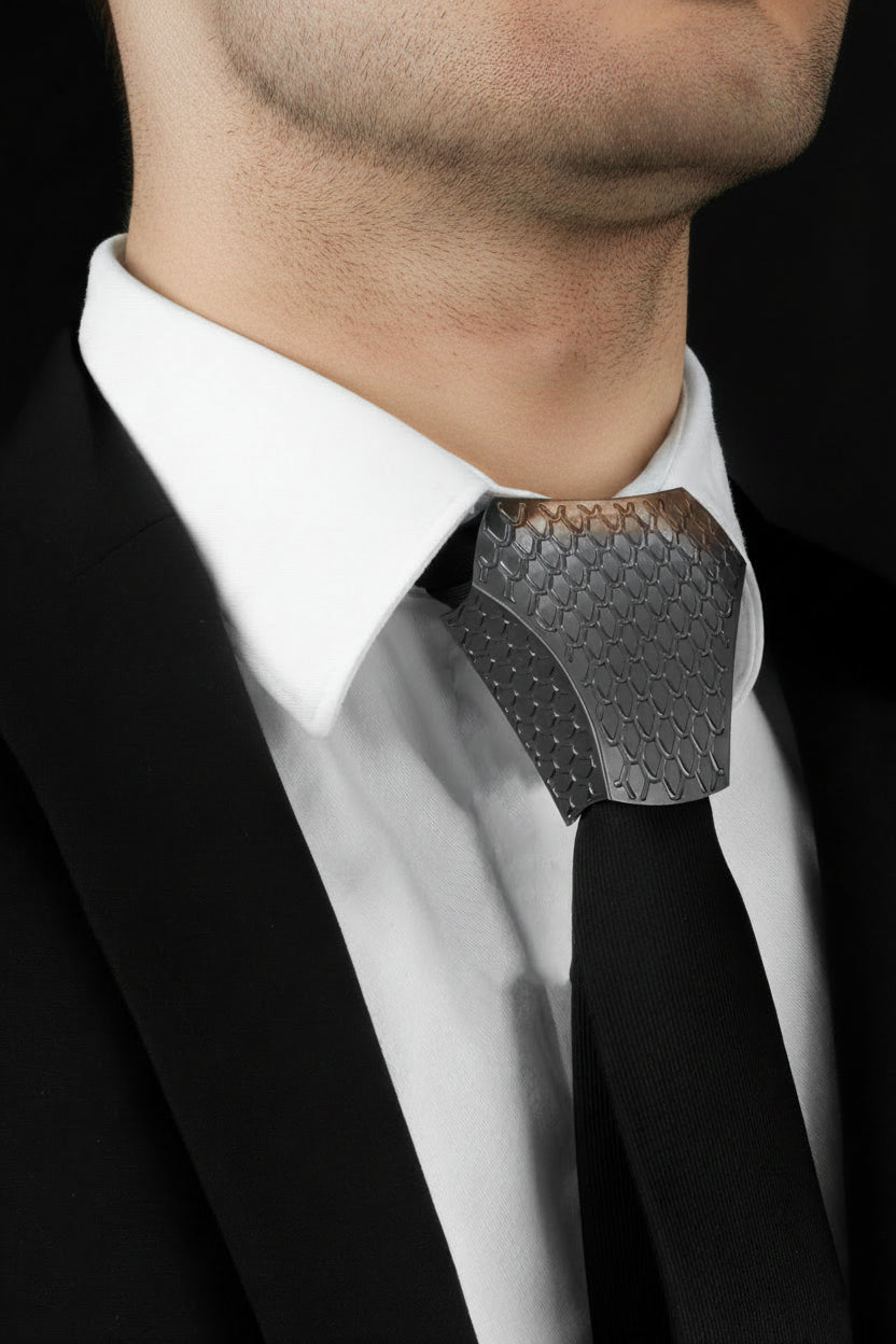 Black tie with geometric pattern over a white shirt collar on a black background