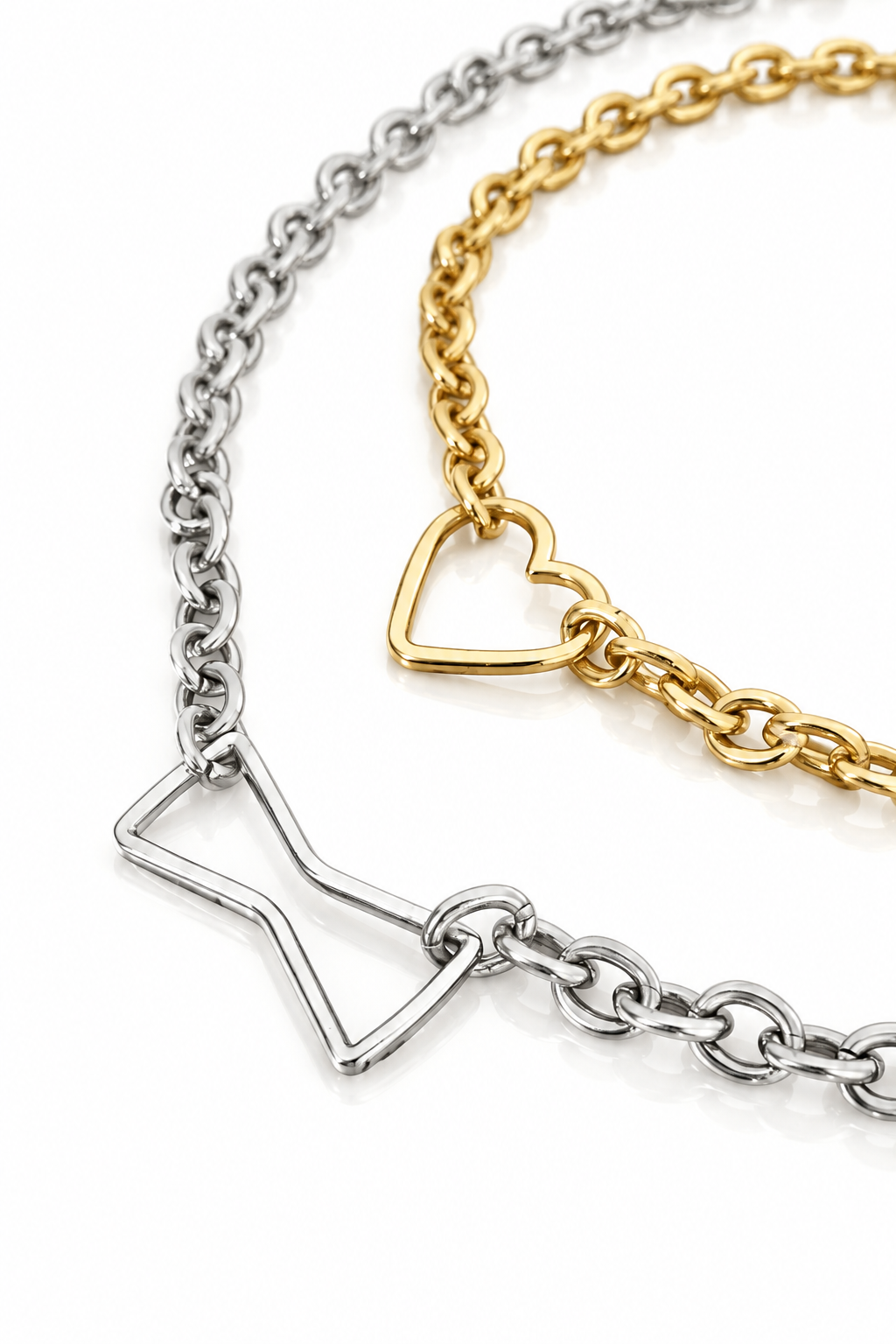 Two delicate chain chokers with heart-shaped charms, one in silver-tone metal and one in gold-tone metal, displayed on a solid red background.