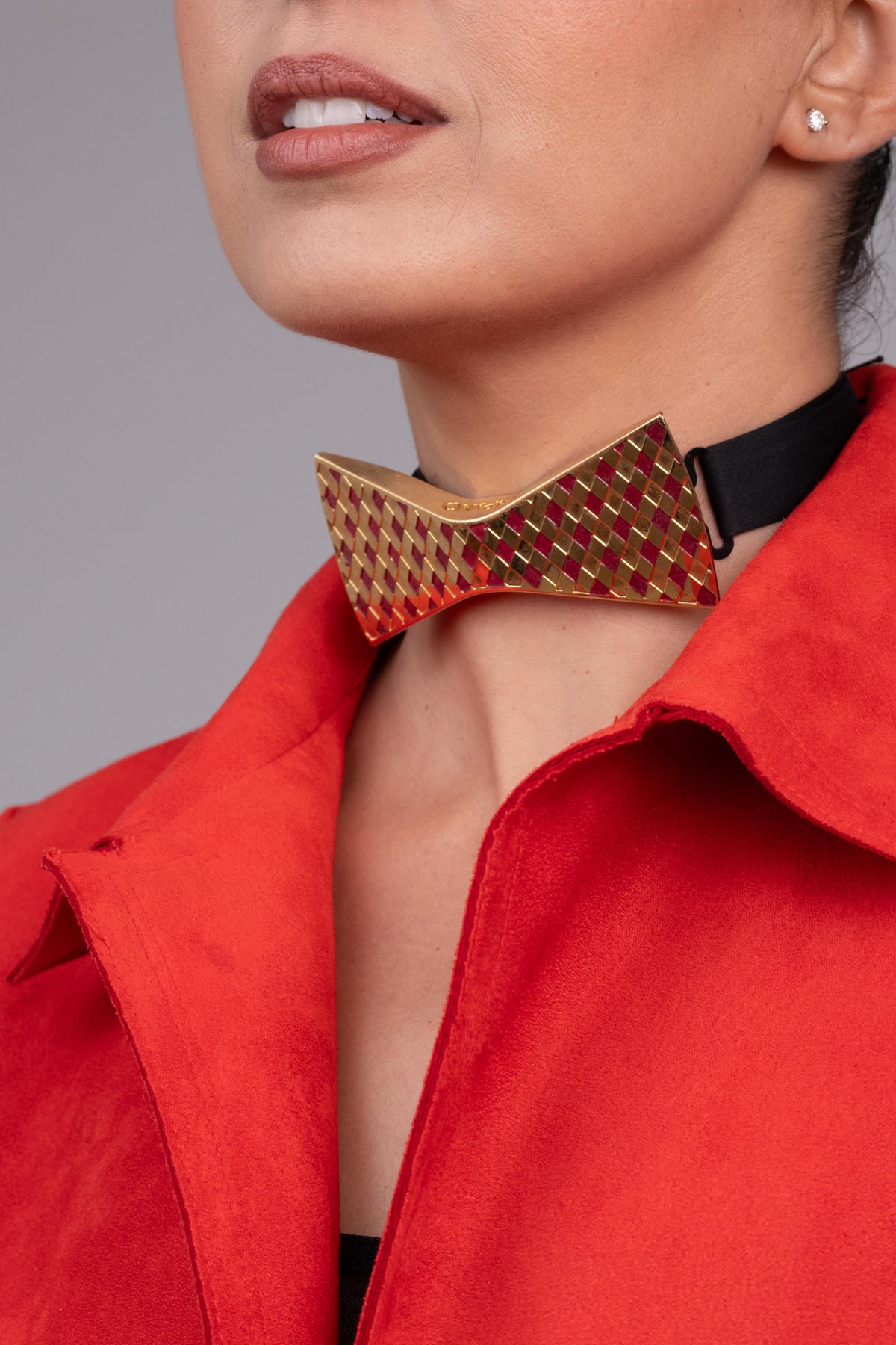 Woman wearing a red coat with a bow tie collar 